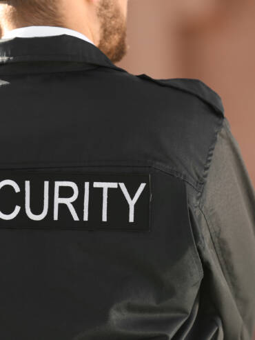 Male security guard outdoors, back view